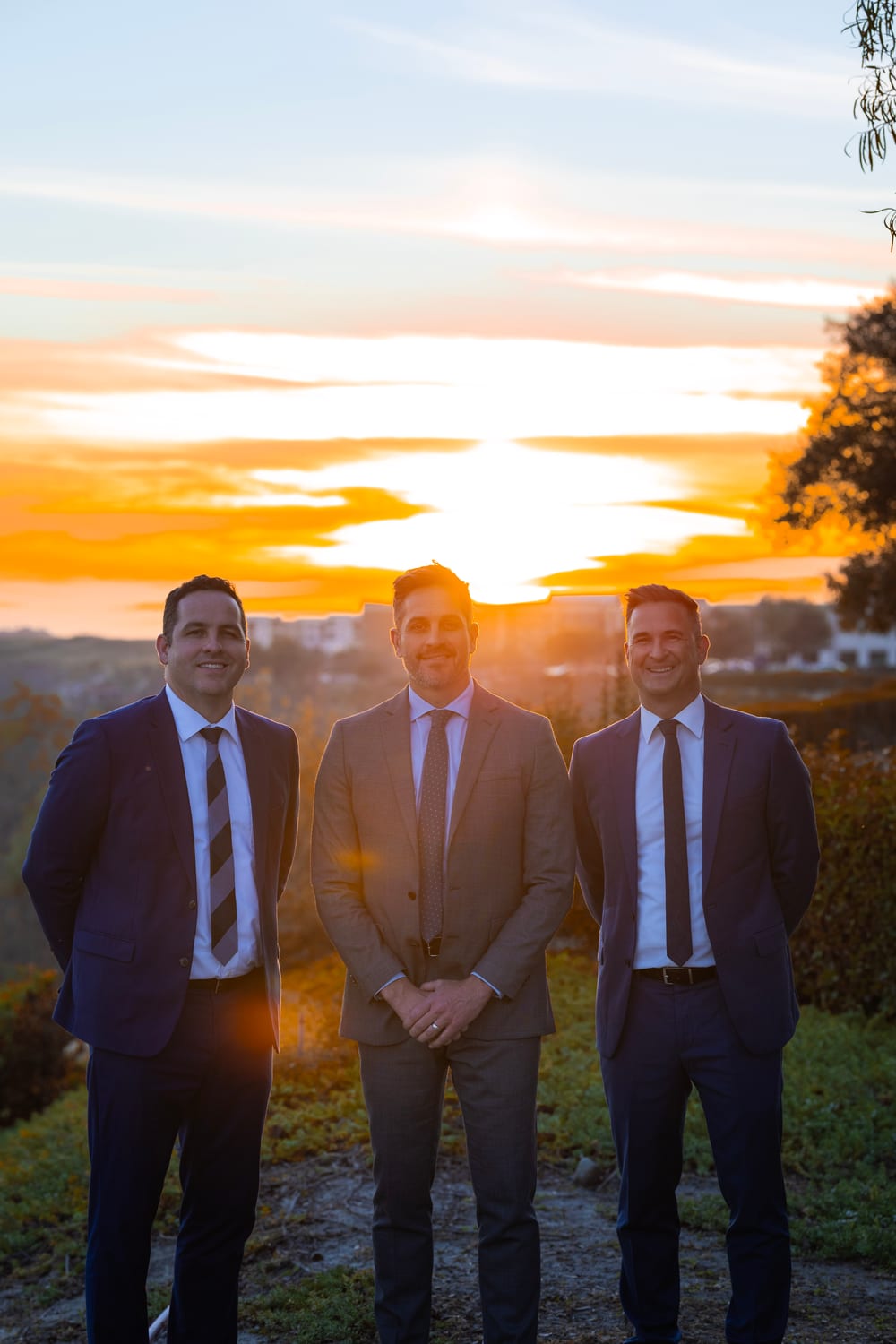 The three Devoted Injury Lawyers attorneys standing together at sunset in Oceanside, California