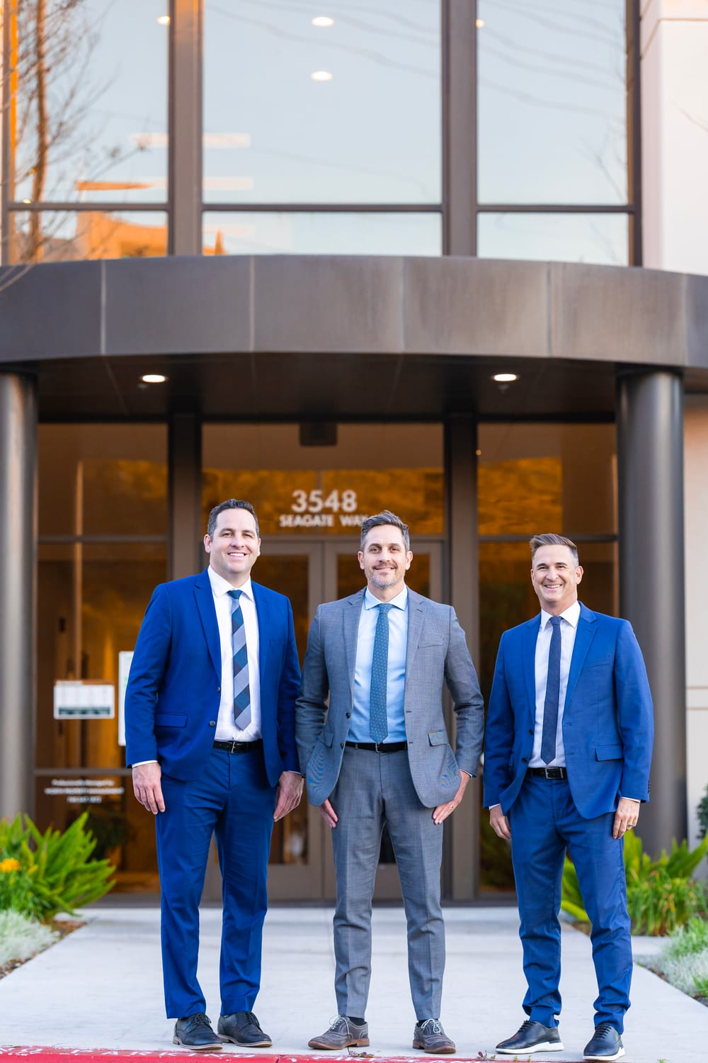 The three Devoted Injury Lawyers attorneys in front of their office at 3548 Seagate Way in Oceanside, California